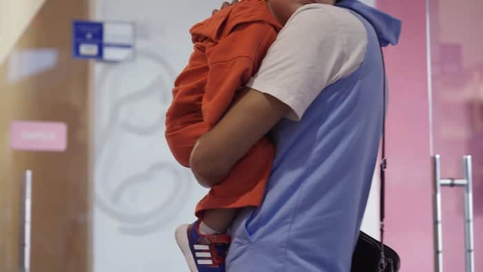parent holding a child at a health clinic in latin america that has received catalytic capital funding from linked foundation