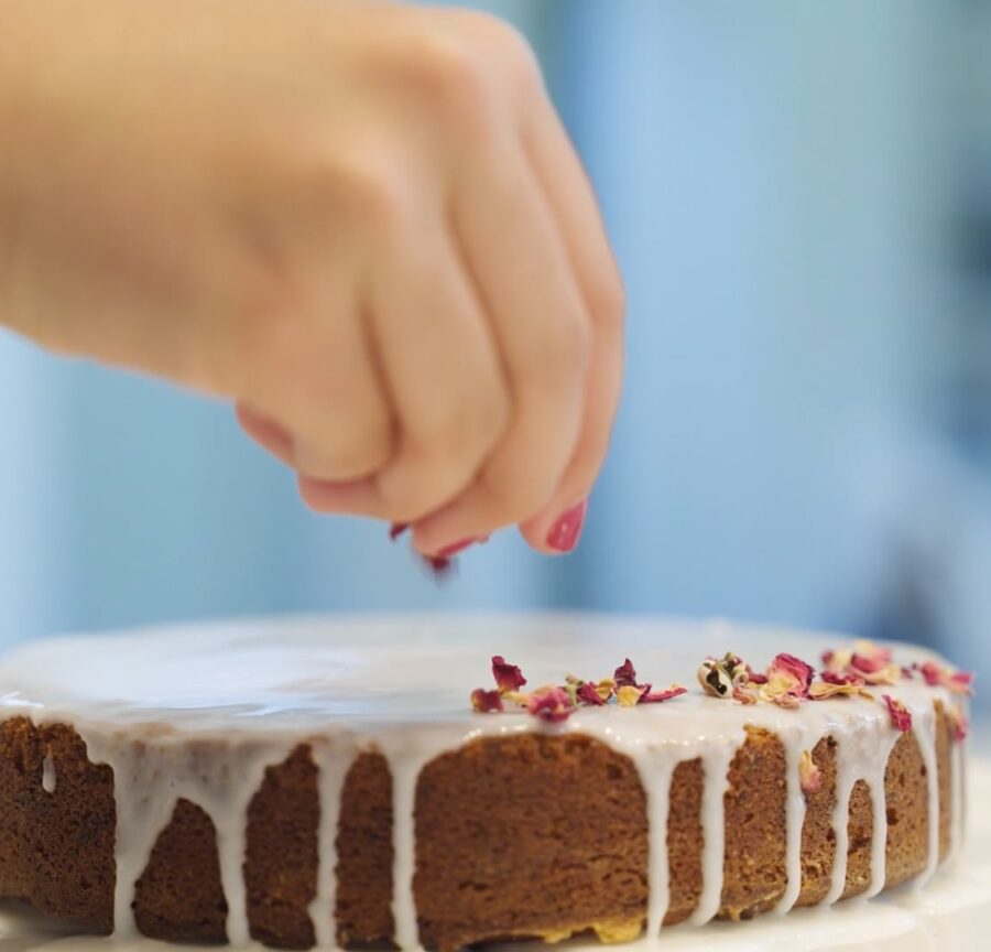 soraya drops rose petals on a cake, part of her youth social entrepreneurship
